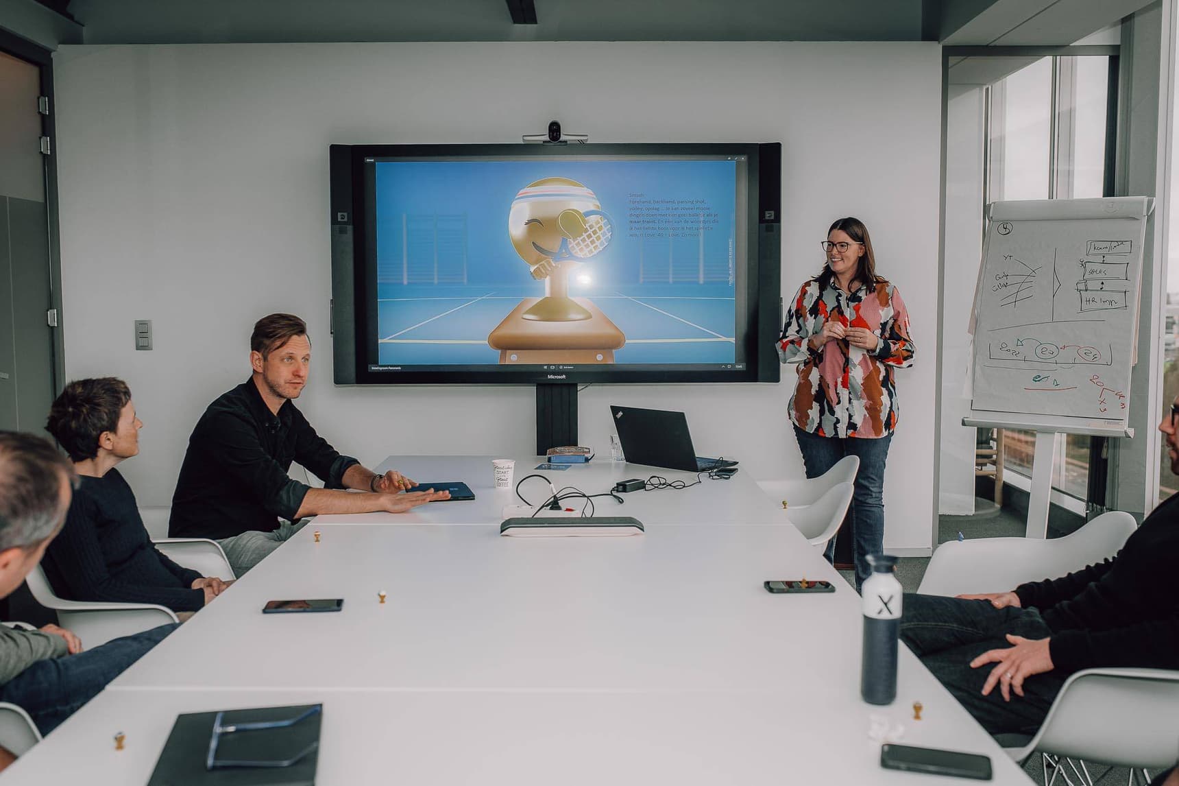 Overleg in een vergaderzaal met een presentatie op groot scherm